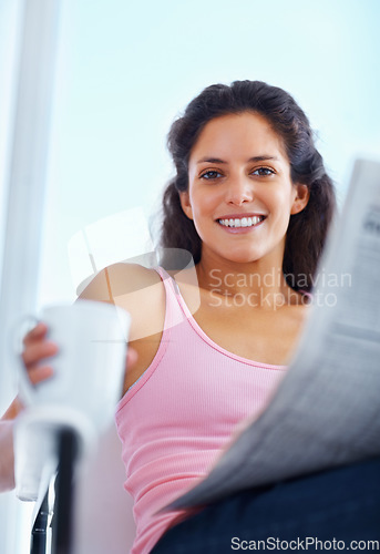 Image of Portrait, smile and woman drinking coffee with newspaper in home, espresso or latte for breakfast to relax in living room in the morning. Face, tea cup and person reading news or info in apartment