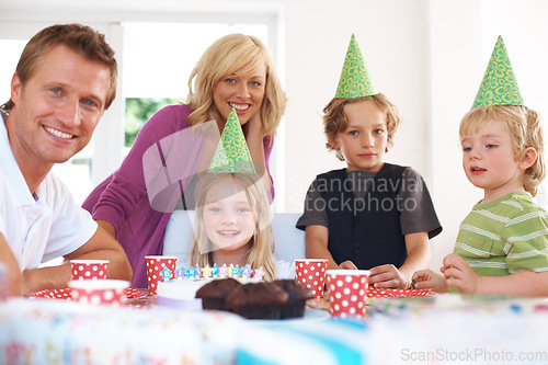 Image of Birthday, party and a family in their home together for the celebration of a milestone with children. Smile, love or a happy mother, father and sibling kids in the living room for an event with cake