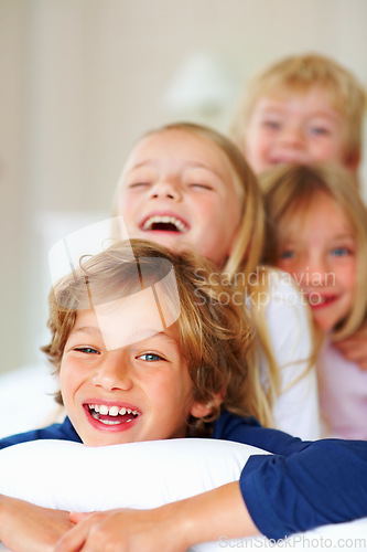 Image of Portrait, love or laughing with brother and sister sibling children on a bed in the home together. Family, happy or bonding with funny boy and girl kids in the bedroom of an apartment on the weekend