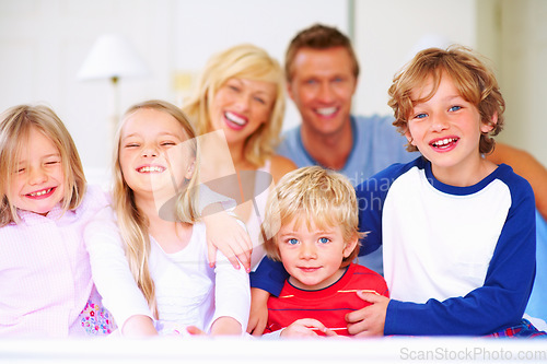 Image of Smile, portrait and parents with children on bed for bonding, relaxing and spending time together. Happy, love and young mother and father resting with kids from Australia in bedroom at family home.
