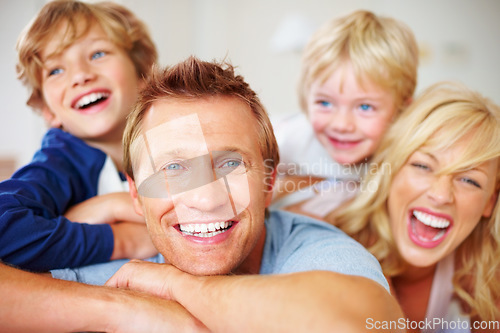 Image of Portrait, smile and a crazy family on a bed together while in their home on a weekend morning. Face, love or funny with a father, mother and kids in the bedroom of an apartment to relax for bonding