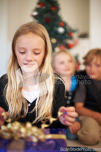 Image of Girl, gift or unwrap ribbon in festive season with happiness, christmas tree or excited siblings in living room. Children, surprise or smile for presents in house, together or celebration on holiday