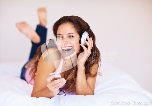 Image of Happy, headphones and portrait of young woman listening to music, playlist or radio at home. Smile, technology and face of female person from Canada relax and streaming song or album in her apartment