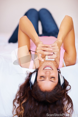 Image of Headphones, smile and woman with player on bed, streaming and relax at home in the morning. Music, happy person on technology in bedroom and listen to radio or audio, sound or song on internet app