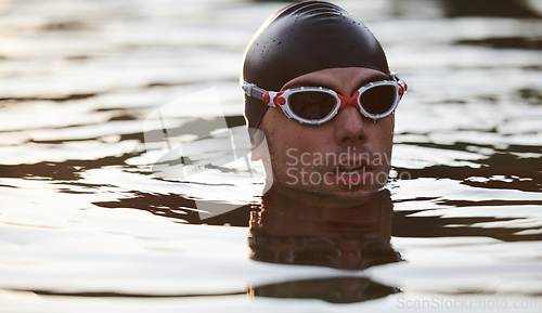 Image of A triathlete finds serene rejuvenation in a lake, basking in the tranquility of the water after an intense training session