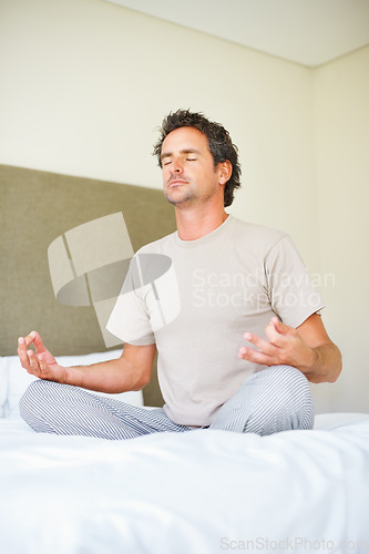 Image of Lotus hands, yoga pose and man on bed with meditation, peace and mental health wellness in his home. Breathing, balance and male person relax in bedroom with spiritual, healing or holistic self care