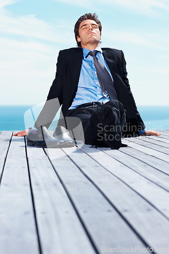 Image of Business man, outdoor and relax on vacation of a corporate professional on holiday with peace on deck. Worker, male employee and suit by sea with calm and blue sky with job and career by ocean