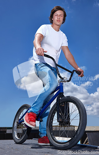 Image of Sky, bicycle and portrait of boy teenager riding for fitness, health or wellness in the road. Smile, sports and young man cycling on bike for transportation, adventure and adrenaline for practice.