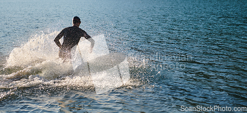 Image of Triathlon athlete starting swimming training on lake