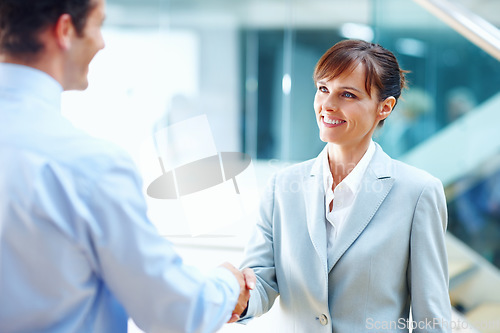 Image of Happy business people, handshake and meeting for partnership, b2b or corporate deal at office. Businessman and woman shaking hands in greeting, introduction or company agreement together at workplace