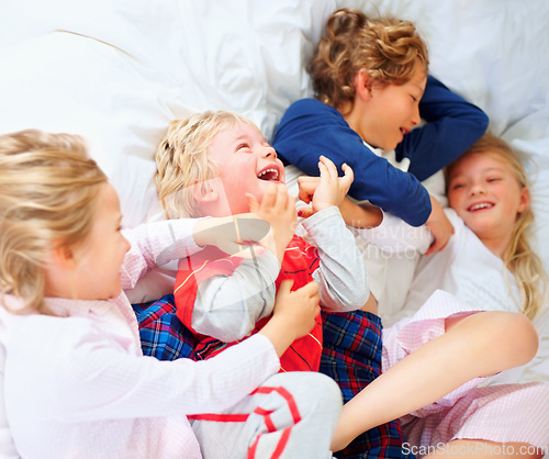 Image of Laugh, playing and above of children in bedroom for bonding, love and cute relationship. Family, home and top view of brothers, sisters and kids for childhood games, fun and playful on bed together