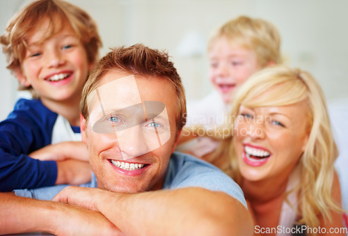 Image of Portrait, love and laughing with a family on a bed together while in their home on a weekend morning. Face, smile or happy with dad, mom and kids in the bedroom of an apartment to relax for bonding