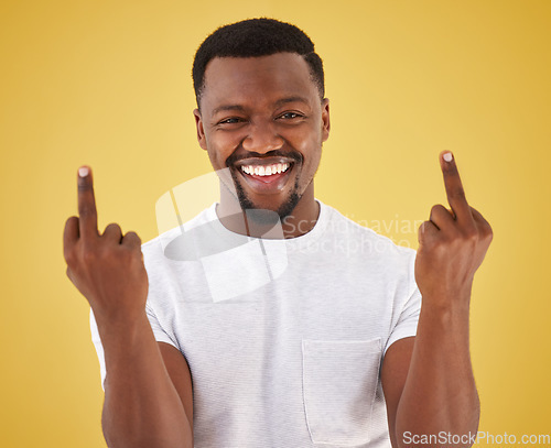 Image of Happy, middle finger and portrait of black man in studio with rude, insulting and bad sign. Emoji, symbol and face of person with hand gesture on yellow background for joke, rebel attitude and laugh