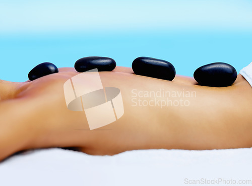 Image of Spa, woman back and hot stone massage outdoor for wellness, healing and stress relief body treatment zoom. Luxury, zen and female person at beauty resort for rock therapy, pamper or peace in Thailand