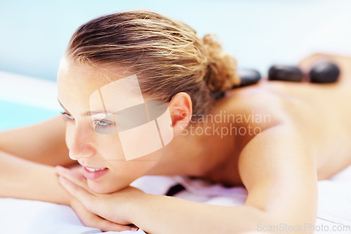 Image of Hot stone, back massage and relax woman at a spa for wellness treatment and detox. Calm, muscle healing recovery and a female person with sleep at resort or hotel with beauty therapist with skincare