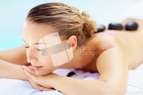 Image of Hot stone, massage and woman sleep at a spa for wellness treatment and detox. Calm, muscle healing recovery and a female person with sleep at a resort or hotel with beauty therapist with skincare