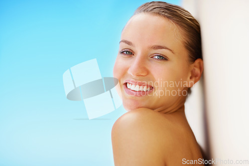 Image of Woman, wall and skincare with portrait, smile or results for promotion, blue sky background or nature. Girl, skin glow and change with cosmetics, wellness or transformation for mockup space outdoor