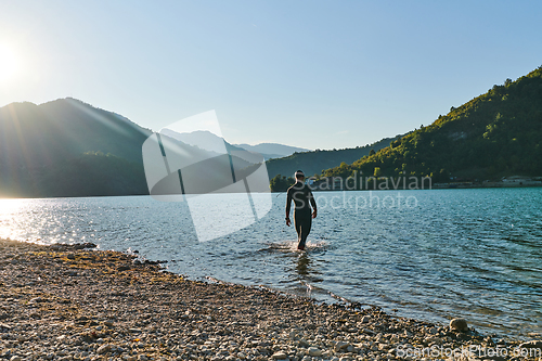 Image of Triathlon athlete starting swimming training on lake