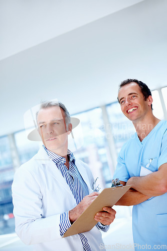 Image of Doctors, men and clipboard in clinic together for thinking, space or vision for medical results. Medic team, partnership and checklist for wellness, healthcare or idea for problem solving at hospital