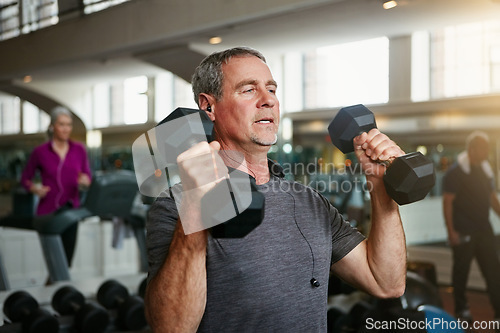 Image of Old man, senior fitness and dumbbells at a gym for weightlifting, challenge or workout, training or bodybuilding. Biceps, arms and elderly person with hand weight for strength, mindset or exercise