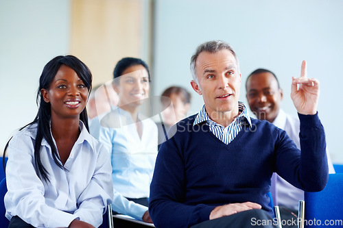 Image of Businessman, hand and question for presentation at conference, workshop or seminar in New York. Diverse group, male ceo or boss with excited expression in audience for discussion, speaker or panel