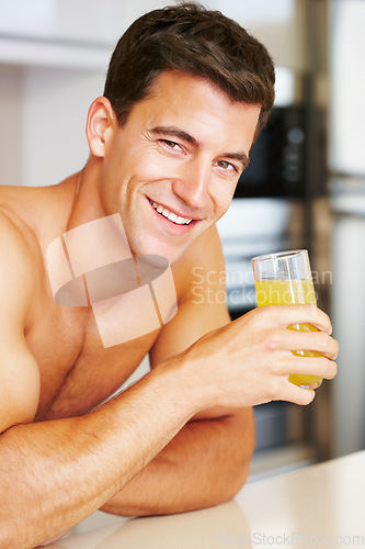 Image of Portrait, smile and man in a kitchen, orange juice and healthy with wellness, morning and diet plan. Face, bare and person with glass, guy and home with natural drink nutrition and happiness with joy