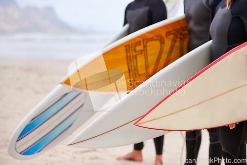 Image of Friends, surfboard and ocean with surfing, fitness and exercise by the sea and beach. Group, outdoor and surfer with travel, training and water on vacation and holiday in Miami with freedom on trip