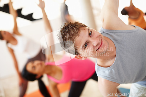 Image of Portrait, smile and stretching, man in yoga class for fitness, commitment and body wellness. Pilates, men and women in gym together for holistic health, mindfulness and happy person at exercise club.