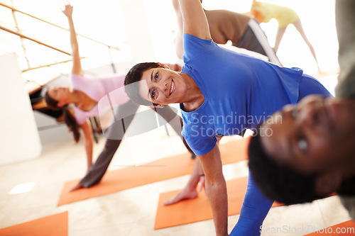 Image of Yoga, stretching and portrait of woman in triangle pose at gym, exercise and healthy body, wellness or pilates. Fitness, happy group and trikonasana balance, flexibility and practice in club together