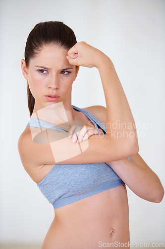 Image of Woman, face or serious in studio with flex for fitness, wellness or workout strength with sportswear. Person, athlete or thinking for biceps, exercise or training on white background or mock up space