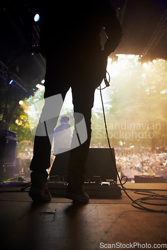 Image of Musician, music festival and back on stage in outdoors, guitarist and event or energy for freedom at party. Person, concert or rave or performer, audio and playing or entertainment for audience