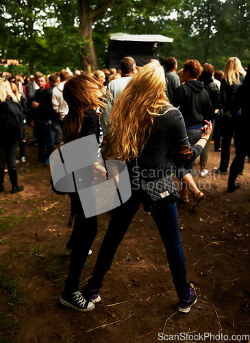 Image of Friends, dancing and fun at outdoor music festival, party and freedom or energy at concert. Women, back and crazy at event, entertainment and bonding outside for friendship, crowd and rave or fashion