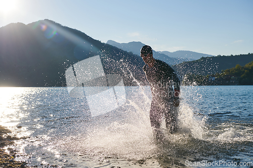 Image of Triathlon athlete starting swimming training on lake