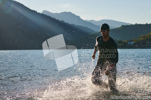 Image of Triathlon athlete starting swimming training on lake