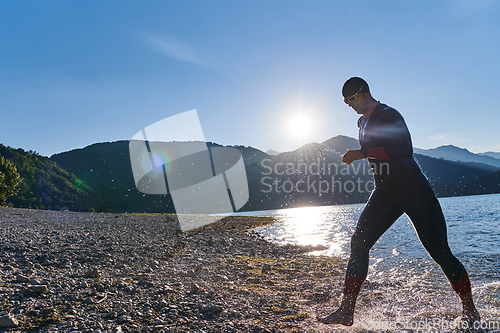 Image of Triathlon athlete starting swimming training on lake