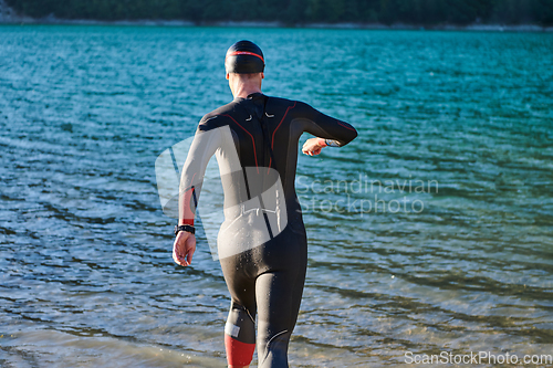 Image of Triathlon athlete starting swimming training on lake