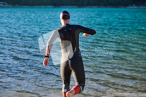 Image of Triathlon athlete starting swimming training on lake