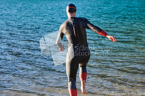 Image of Triathlon athlete starting swimming training on lake