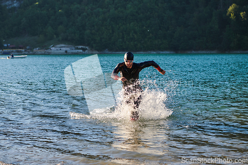 Image of Triathlon athlete starting swimming training on lake