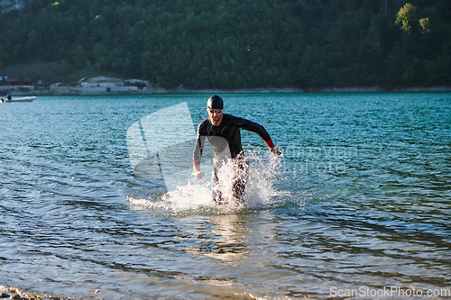 Image of Triathlon athlete starting swimming training on lake