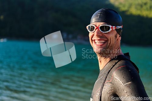 Image of Authentic triathlon athlete getting ready for swimming training on lake