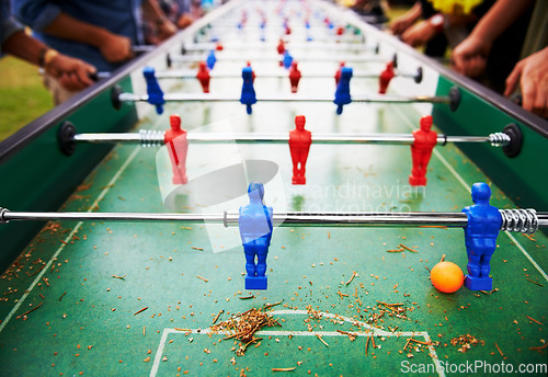 Image of Playing, foosball and people outdoor with table, game or closeup on competition with ping pong ball. Soccer, board and small plastic football players or toys for social, event or sport at pub for fun