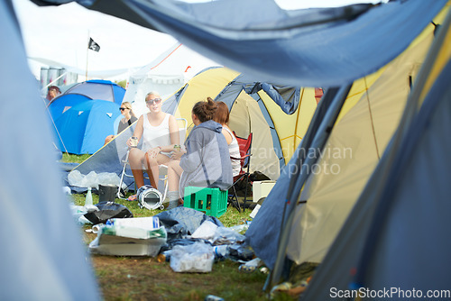 Image of Camping, tent and friends with drinks at a festival, event or group in conversation with garbage on ground. People, talking and relax with beer at party in summer, vacation or travel on holiday