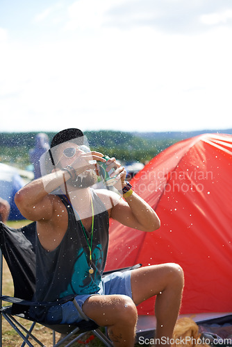 Image of Man, drinking beer and fun in outdoors, music festival and alcohol and relaxing at party or camp. Male person, wine and crazy in nature, outside and freedom or energy for celebration at social event