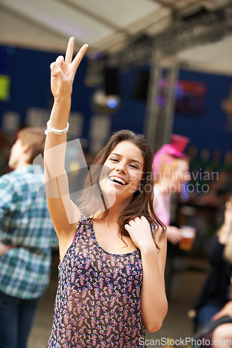 Image of Woman, peace sign and smile in portrait, music festival and fun on vacation or traveling. Female person, face and holiday in Ibiza, casual and cool fashion for party, concert and emoji for freedom