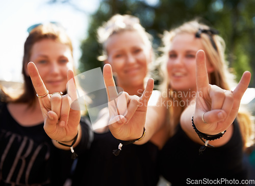 Image of Friends, portrait and women with rocker hands at a music festival, concert of party outdoor together. Devil horns, emoji and face of female group outside for fun, celebration and rock event in a park