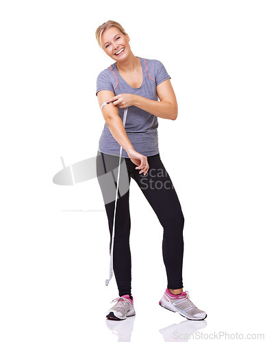 Image of Fitness, measuring tape on arm and portrait of happy woman with smile, workout and wellness with healthy body in studio. Health, exercise and girl with weight loss measurement on white background.