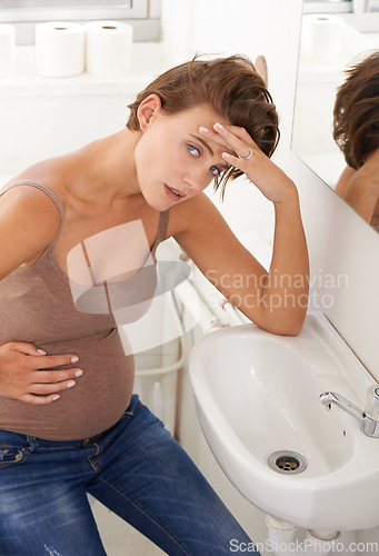 Image of Nausea, pregnant woman and morning sickness in basin unhappy and hand on stomach for discomfort. Exhausted, moody and frustrated with illness, pregnancy and struggling with migraine pain on sink