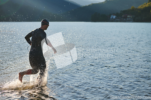Image of Triathlon athlete starting swimming training on lake