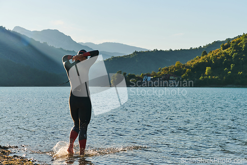 Image of Triathlon athlete starting swimming training on lake